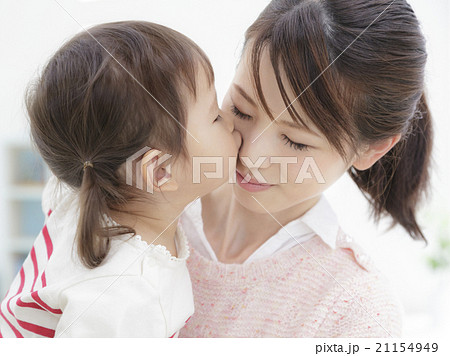 母親にキスする女の子の写真素材