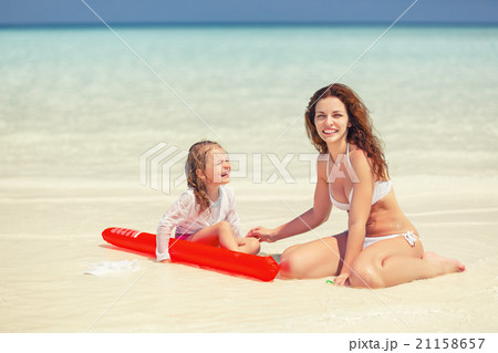 Mother and daughter playing on the beach 21158657