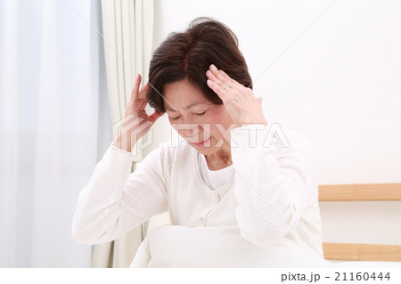ベッドで頭を抱える中高年女性 21160444
