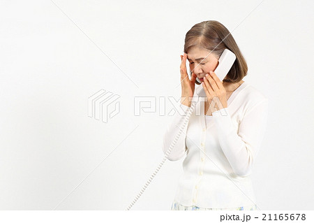 電話をかけて表情が曇るシニア女性 21165678