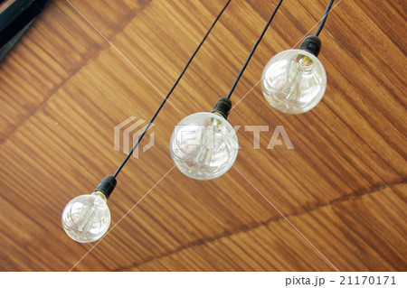 Three retro light bulbs hanging from wood ceiling  21170171