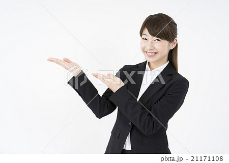 ビジネススーツを着た魅力的な笑顔が素敵な女性「斜め」両手でご案内こちらです、どうぞ、業務案内、説明 ビジネススーツを着た魅力的な笑顔が素敵な女性「斜め」両手でご案内こちらです、どうぞ、業務案内、説明 21171108