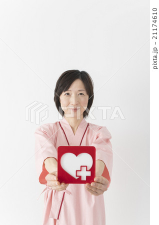 検査着をきてハートのパネルを持つミドル女性 検査着をきてハートのパネルを持つミドル女性 21174610