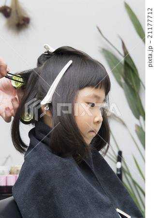 美容院で髪の毛をセットしてもらう子供の写真素材