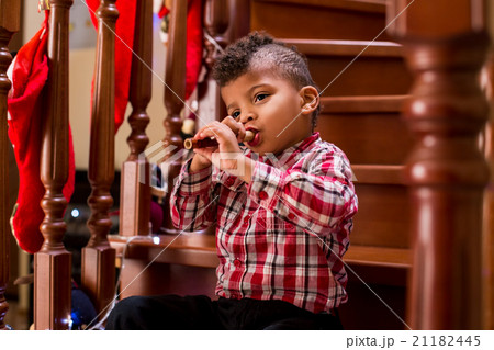 Kid plays flute on stairs. 21182445