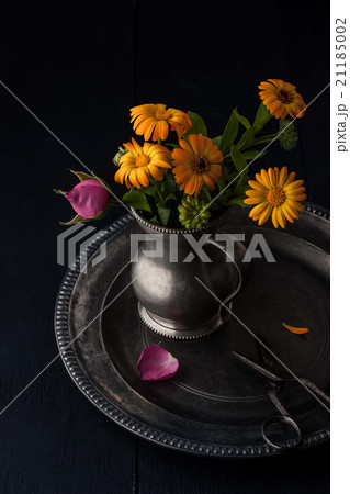 Bouquet of flowers in the old metal jug  21185002