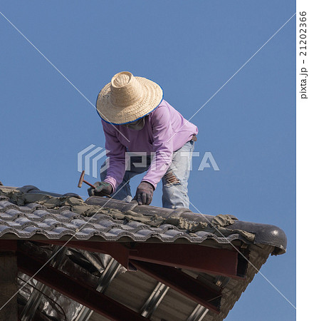 workers installing roof tiles for home building 21202366