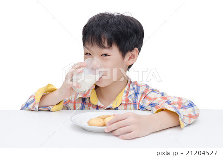 Asian boy eating cookies with milk over white 21204527