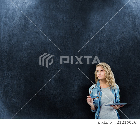 Composite image of woman holding eyeglasses and digital tablet 21210026