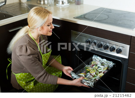 Woman cooking fish in oven Woman cooking fish in oven 21215462