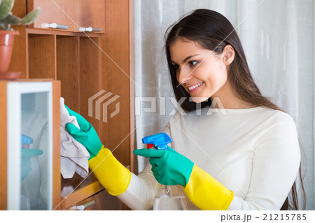 Young brunette dusting at home. 21215785
