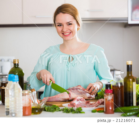 Young woman cooking lamb for dinner at home Young woman cooking lamb for dinner at home 21216071