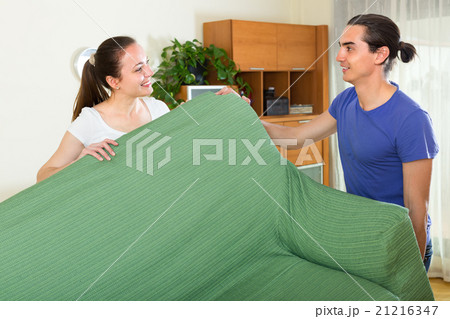 Couple moving furniture in room Couple moving furniture in room 21216347
