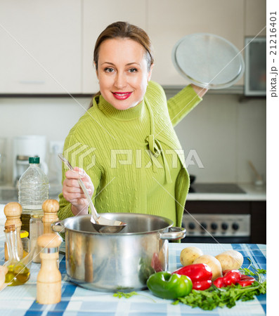 Woman cooking soup in kitchen 21216401