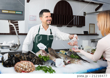 Seller and customer in fish store. Seller and customer in fish store. 21216477