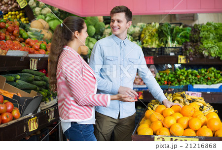 Young brunette girl and boyfriend buying citruses i 21216868