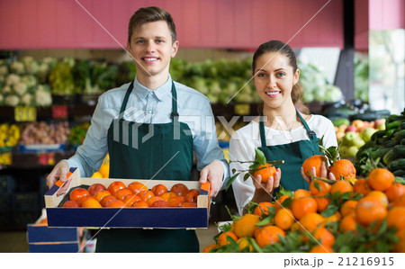 Supermarket workers selling oranges Supermarket workers selling oranges 21216915