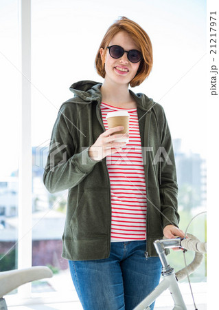 Cute hipster with her bike and disposable cup Cute hipster with her bike and disposable cup 21217971