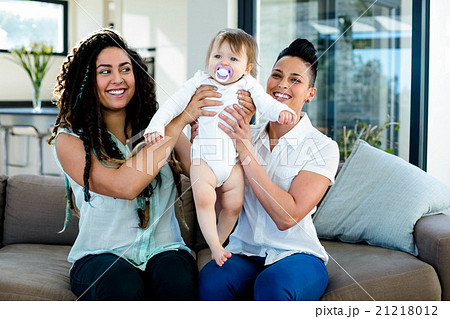 Lesbian couple playing with their baby Lesbian couple playing with their baby 21218012