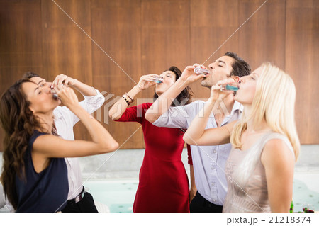 Young and handsome group of friends drinking shots 21218374