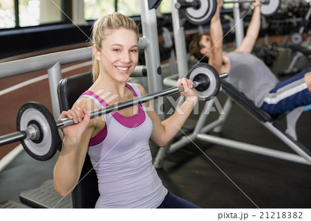 Fit woman lifting barbell 21218382