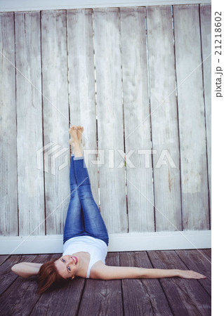 smiling hipster woman with her legs against the wall 21218602