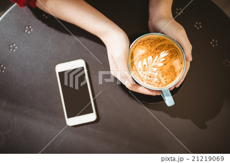Woman holding a cup of coffee Woman holding a cup of coffee 21219069