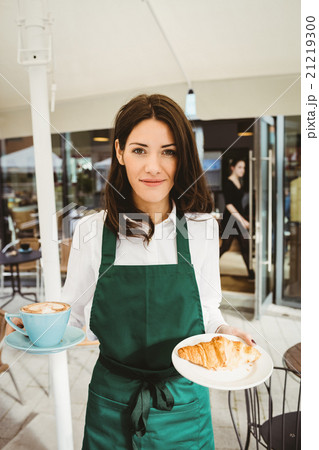 Waitress posing with coffee and croissant Waitress posing with coffee and croissant 21219300