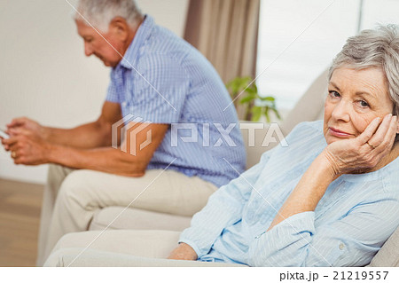 Worried senior woman sitting on sofa Worried senior woman sitting on sofa 21219557