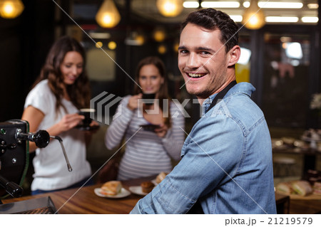 Smiling barista looking back at the camera 21219579