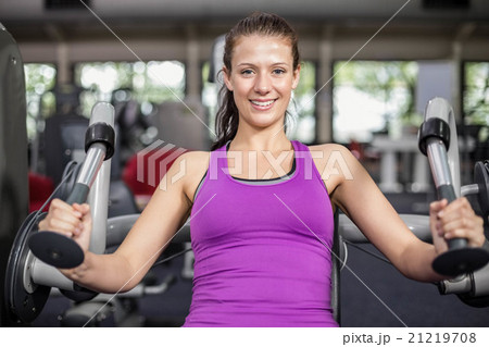 Fit woman using weight machine Fit woman using weight machine 21219708