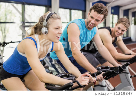 Fit group of people using exercise bike together Fit group of people using exercise bike together 21219847
