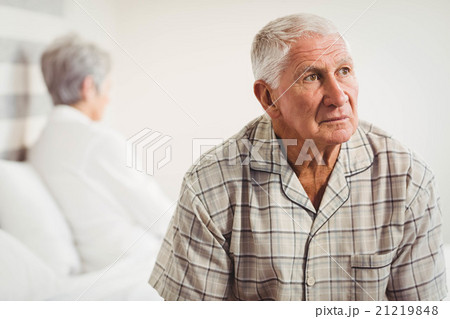 Upset senior man sitting on the opposite ends of the bed Upset senior man sitting on the opposite ends of the bed 21219848