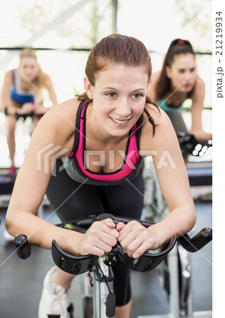 Fit group of people using exercise bike together Fit group of people using exercise bike together 21219934