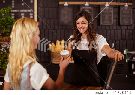 Pretty waitress giving cup of coffee to customer Pretty waitress giving cup of coffee to customer 21220119