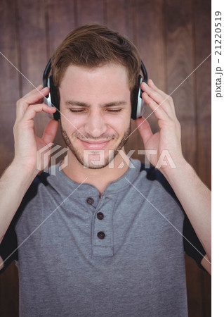 Handsome hipster listening to music with headphones Handsome hipster listening to music with headphones 21220519