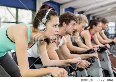 Fit group of people using exercise bike together Fit group of people using exercise bike together 21221008