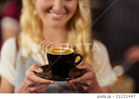 Portrait of smiling pretty customer holding cup of coffee 21221447
