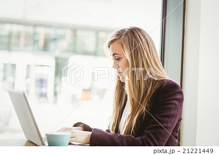 Cute blonde girl using her laptop 21221449