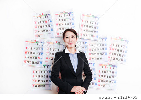 カレンダーの前で笑顔のビジネスウーマン カレンダーの前で笑顔のビジネスウーマン 21234705