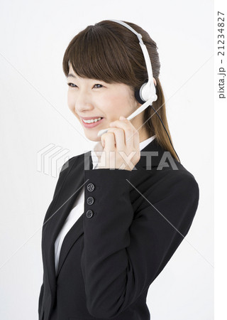オペレーター：ヘッドセットのマイクを片手に優しく微笑むスーツを着た若く可愛いサポートセンターの女性縦 21234827