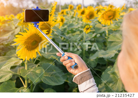 woman holding selfie stick taking photo 21235427
