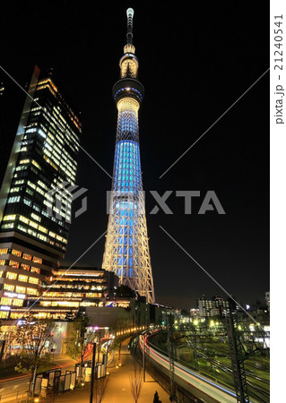 夜のスカイツリーと根元を通過する列車の写真素材