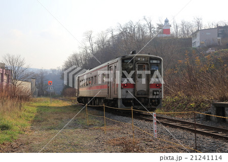 増毛駅に到着する気動車と増毛灯台 21241114