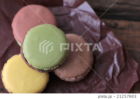 グラシンペーパーに乗せたチョコレートとピスタチオのマカロン 21257603