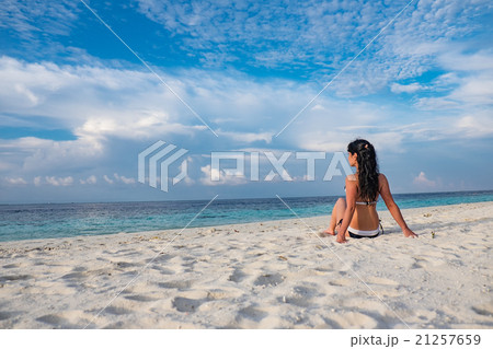 Girl walking along a tropical beach in the Maldives. Girl walking along a tropical beach in the Maldives. 21257659