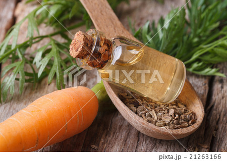 Useful carrot seed oil in glass bottle closeup Useful carrot seed oil in glass bottle closeup 21263166