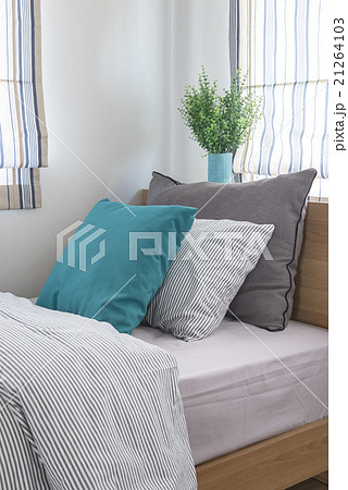 single wooden bed with pillows and vase of plant single wooden bed with pillows and vase of plant 21264103