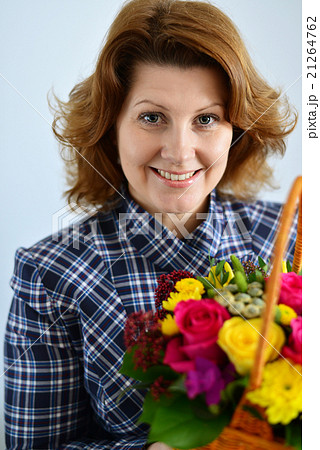 woman holding a basket of flowers woman holding a basket of flowers 21264762