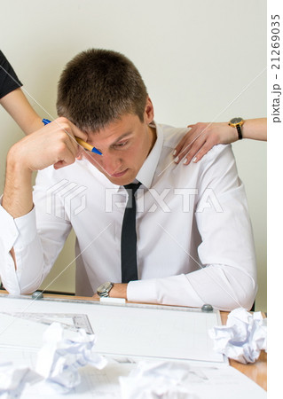 Consoling a moody businessman at work Consoling a moody businessman at work 21269035